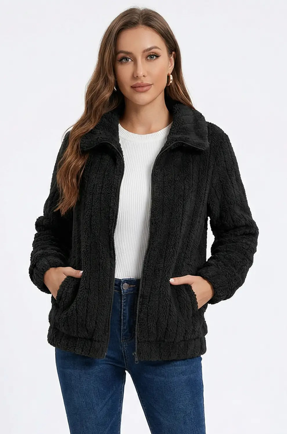 Woman wearing a black cable knit jacket on a white background