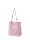 Pink tote bag with a small label on a white background